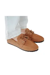 Mocasines de gamuza color tostado con lazo frontal decorativo y detalle de pasacintas laterales. Poseen suela flexible antideslizante.