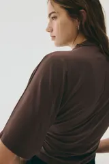 Top de punto elástico color marrón chocolate, con cuello alto, mangas al codo y diseño con fruncidos laterales que generan un efecto drapeado.