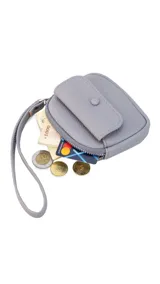 Monedero compacto de símil cuero con correa de mano, cierre perimetral y bolsillo frontal con solapa y botón a presión.