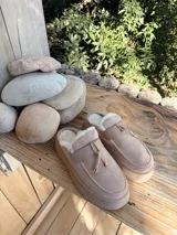 Suecos de símil gamuza color beige, con interior forrado en corderito sintético, plataforma y detalle de tira frontal con cordones y punteras metálicas.