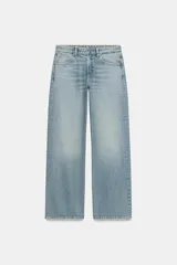 Jeans de tiro medio con corte relajado y diseño de cinco bolsillos. Presenta trabillas en la cintura, cierre frontal con cremallera y botón metálico, con un acabado de lavado desgastado.