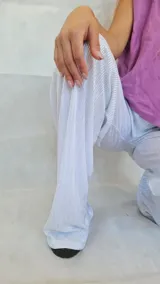 Pantalón de corte amplio y fluido, confeccionado en tela plisada con acabado metalizado brillante. Presenta cintura elástica para un ajuste cómodo y diseño de pierna ancha.