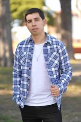Sobrecamisa de hombre a cuadros en tonos celeste, blanco y azul marino, con forro interno de corderito, bolsillos en el pecho y cierre frontal con botones.
