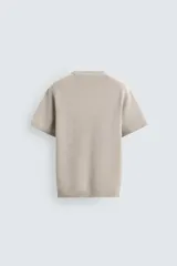 Camiseta de punto de algodón con textura perlada, corte regular fit, cuello redondo y manga corta con terminaciones en rib.