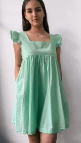 Vestido corto verde agua, con escote cuadrado, mangas cortas con volados y bolsillos laterales.