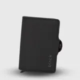 Tarjetero compacto con sistema deslizador para tarjetas, compartimentos internos adicionales y espacio para billetes. Diseño minimalista con textura granulada y cierre lateral con botón a presión.