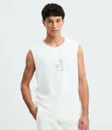 Musculosa blanca de algodón, de corte comfort y cuello redondo. Presenta un estampado localizado en el pecho con un diseño de palmeras y un atardecer en tonos rosados y naranjas.