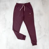 Pantalón de jogging color bordó, con cintura elástica ajustable con cordón y puños en los tobillos.