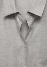 Camisa de viscosa color gris claro, de corte recto, con cuello camisero, cierre frontal con botones, bolsillo de parche en el pecho y mangas largas abotonadas.