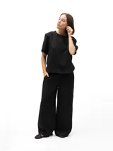 Pantalón negro de lino de corte holgado, con cintura elástica, dos bolsillos laterales y un bolsillo trasero.