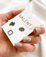 Set de tres pares de aros Valente de acero color plateado. Incluye un par con forma de cactus, un par con forma de ojo y un par con forma de cuadrado.