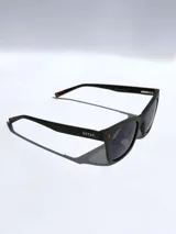 Lentes de sol Osten modelo Porto, con armazón de color negro mate, diseño rectangular y cristales oscuros polarizados. Presentan un detalle minimalista en color naranja en el frente y en las patillas.