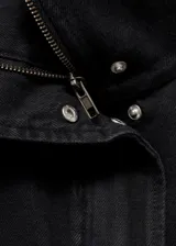Anorak de estilo utilitario confeccionado en tejido de algodón tipo denim, con diseño oversize, cuello embudo, cierre frontal de cremallera y botones a presión, y cuatro bolsillos de parche con solapa en la parte delantera.