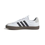 Championes Adidas modelo VL Court, con diseño de inspiración skate. Presentan una parte superior de cuero sintético blanco con las icónicas tres bandas laterales en negro y detalles en gamuza gris en la puntera y el talón. Cuentan con una suela de caucho vulcanizado en color marrón oscuro que proporciona durabilidad y un estilo urbano.