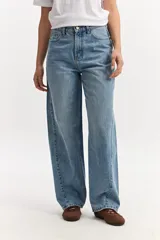 Jean baggy de tiro medio confeccionado en algodón, con diseño de piernas amplias, estilo slouchy y efecto gastado.