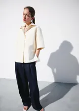 Pantalón de traje tiro medio, corte recto y largo, con diseño de raya diplomática, pinzas y bolsillos laterales.