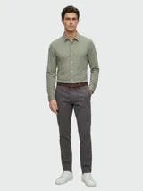 Camisa de vestir slim fit de tejido stretch color verde militar, con cuello camisero, manga larga y cierre frontal de botones.