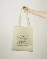 Tote bag de color beige con estampado gráfico en color verde que ilustra un perro con lentes sobre una manta, acompañado por la frase 'Otoño Uruguayo'. Cuenta con doble asa larga para llevar al hombro.