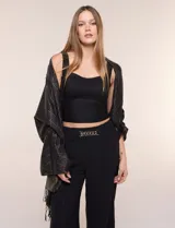 Pashmina rectangular negra con diseño jacquard de rombos, destellos metalizados dorados y flecos anudados en los extremos.