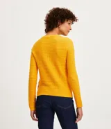 Blusa de punto color celeste con textura ondulada, cuello redondo y mangas largas.