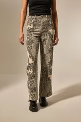Pantalón de algodón con estampado de piel de serpiente en tonos beige y negro, corte recto y tiro alto.