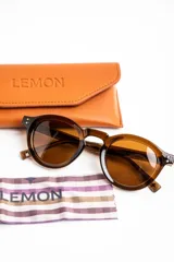 Lentes de sol polarizados con armazón redondo de carey y cristales marrones.