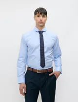 Camisa de vestir Harrington color celeste, de manga larga, con cuello clásico y cierre frontal de botones.