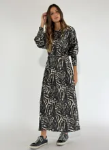 Vestido largo azul con estampado abstracto en blanco y negro, corte recto y mangas largas abullonadas.