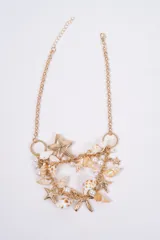 Collar de cadena dorada con diseño temático marino, decorado con múltiples dijes de caracoles, conchas y estrellas de mar, intercalados con pequeñas perlas blancas.