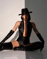 Catsuit anatómico negro de lycra elastizada, con capucha y escote pronunciado.