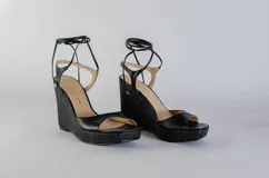 Sandalias de plataforma con taco corrido revestido en yute, confeccionadas en cuero color lila. Presentan diseño de puntera abierta y tiras largas para atar alrededor del tobillo.