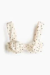 Top de bikini balconette de color beige con estampado de lunares negros. Cuenta con copas con aros y tirantes anchos.