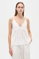 Musculosa blanca de algodón con diseño de broderie, escote en V, tirantes finos regulables y corte holgado.