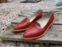 Mocasines de cuero plateado con acabado texturado, diseño clásico con costuras visibles y vira de suela natural cosida. Cuenta con taco plano de 2 cm y plantilla anatómica.