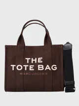 Bolso tipo tote de Marc Jacobs, confeccionado en lona resistente color beige. Presenta el logo estampado en contraste en el frente, doble asa superior y cierre superior con cremallera.