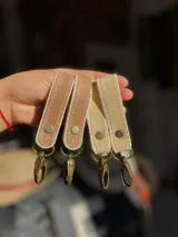 Llaveros de cuero con mosquetón metálico y remache a presión.