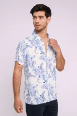 Camisa de hombre de manga corta con estampado de flores azules sobre fondo blanco, cuello clásico y cierre frontal con botones.