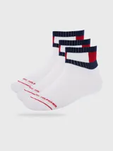 Pack de tres pares de medias de caña media, confeccionadas en tejido de algodón con detalles distintivos de la marca. Presentan un diseño con franjas horizontales en azul, blanco y rojo en el puño elástico y el logo de Tommy Hilfiger bordado en la parte superior del pie.