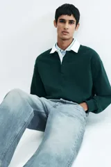 Jeans de cinco bolsillos en denim de algodón rígido. Corte holgado de cadera a bajo con pierna recta amplia y tiro caído. Modelo de cintura estándar con cierre de botones. Presenta un lavado celeste claro con efecto degradado o 'dip-dye' en la parte inferior.