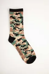 Medias largas con estampado de camuflaje en tonos verde, marrón y beige, con puntera, talón y borde superior en negro.