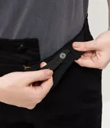 Pantalón de jean corte flare color negro, con cintura estructurada, bolsillos funcionales y recortes frontales con remaches brillantes.