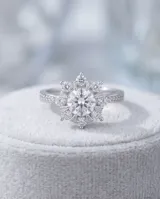 Anillo de plata 925 con diseño floral central compuesto por circonias brillantes y banda con pavé de piedras pequeñas.