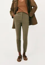 Pantalón sastrero de corte ajustado y tobillero, color verde militar, con bolsillos laterales y trabillas para cinturón.