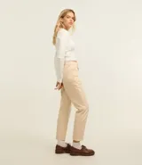 Pantalón mom de sarga color beige, con cintura alta, trabillas, bolsillos delanteros y traseros, cierre con botón y cremallera.