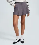Short de sastrería color gris, con diseño estructurado, pliegues delanteros y cierre interno. Incluye un cinturón fino desmontable.