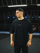 Remera negra de algodón, corte oversize, con inscripción 'GAINS.' en el frente.