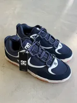 Championes DC modelo Kalynx Zero, color azul marino con detalles en blanco y suela de goma color caramelo. Confeccionados en malla y gamuza, con cordones azules y logo de la marca en el lateral y la lengüeta.