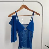 Top azul eléctrico con escote halter y abertura en el centro del busto. Incluye mangas largas de tul a juego.