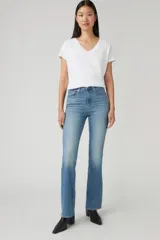 Jean azul de tiro alto, corte bootcut, con lavado medio y efecto desgastado en los muslos.