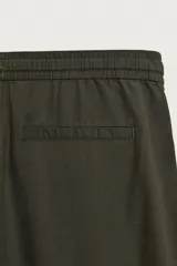 Pantalón de corte relajado confeccionado en una mezcla de algodón y lino. Presenta cintura elástica con cordón ajustable, bolsillos laterales y bolsillos traseros de vivo.